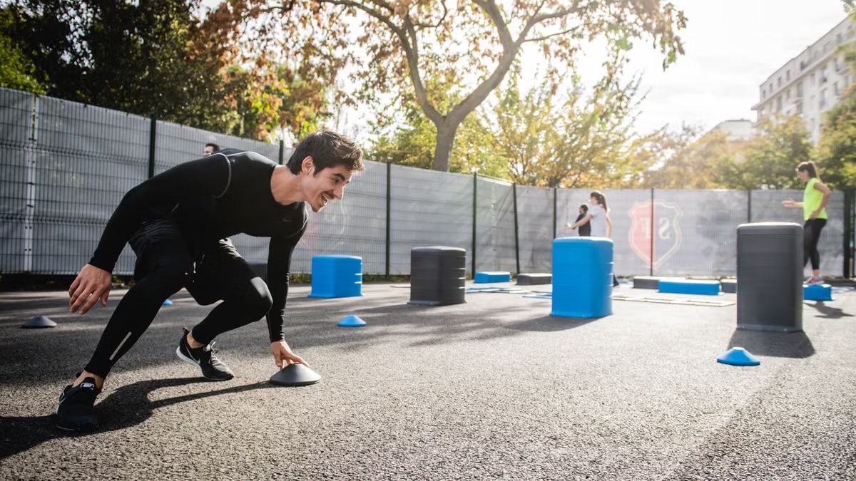 Fitness enthusiasts doing outdoor exercise in a city park, Boulogne-Billancourt, France.